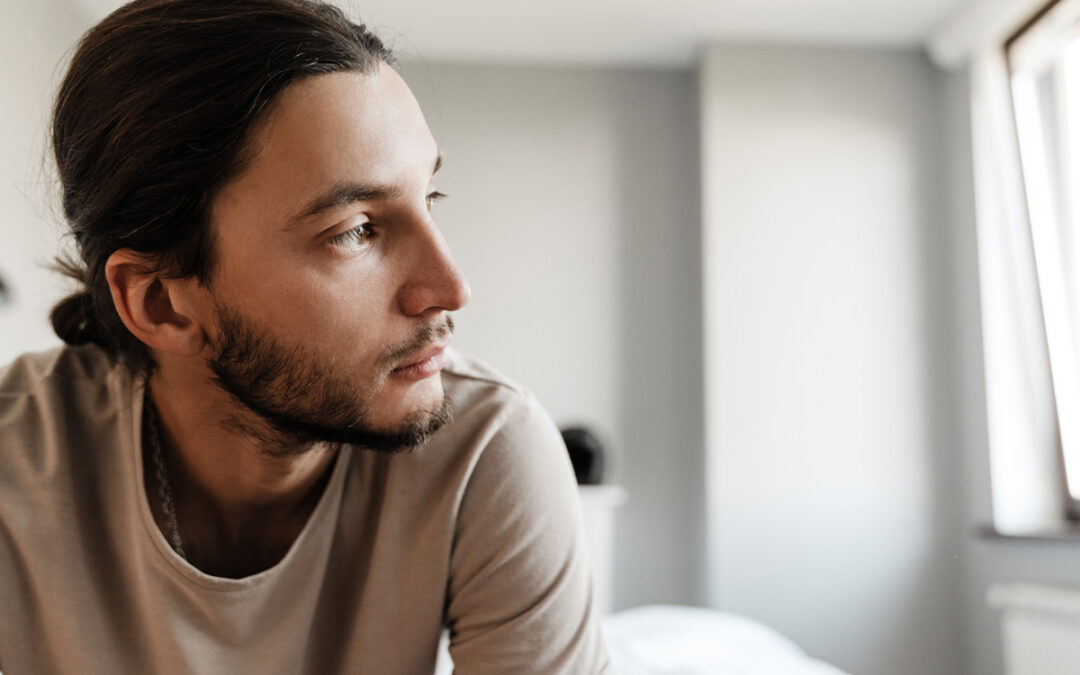 young man depressed sitting on bed